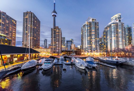 Canadá Puerto deportivo de Toronto al atardecer, con rascacielos y la CN Tower de fondo.