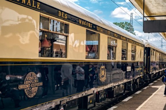 Venice Simplon Orient Express Vagón de tren clásico en una estación, con detalles en azul y dorado.